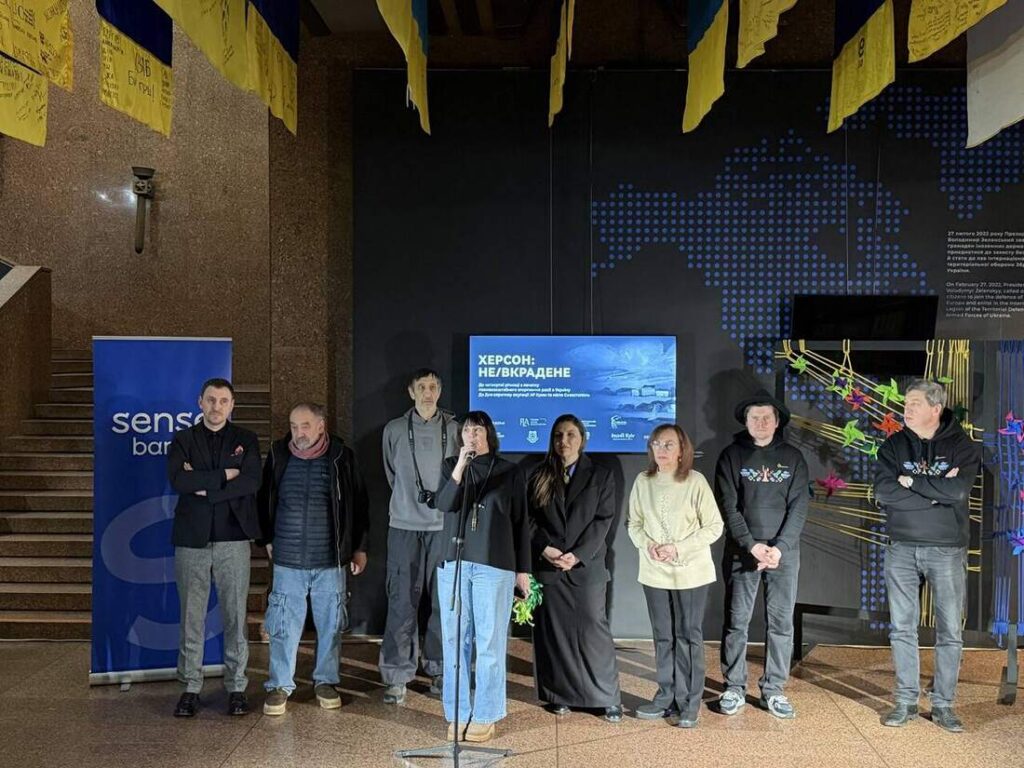 Учасники відкриття виставки під прапорами військових підрозділів